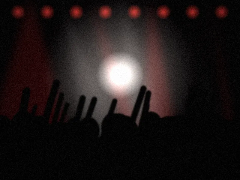 Público en un concierto bajo luces rojas